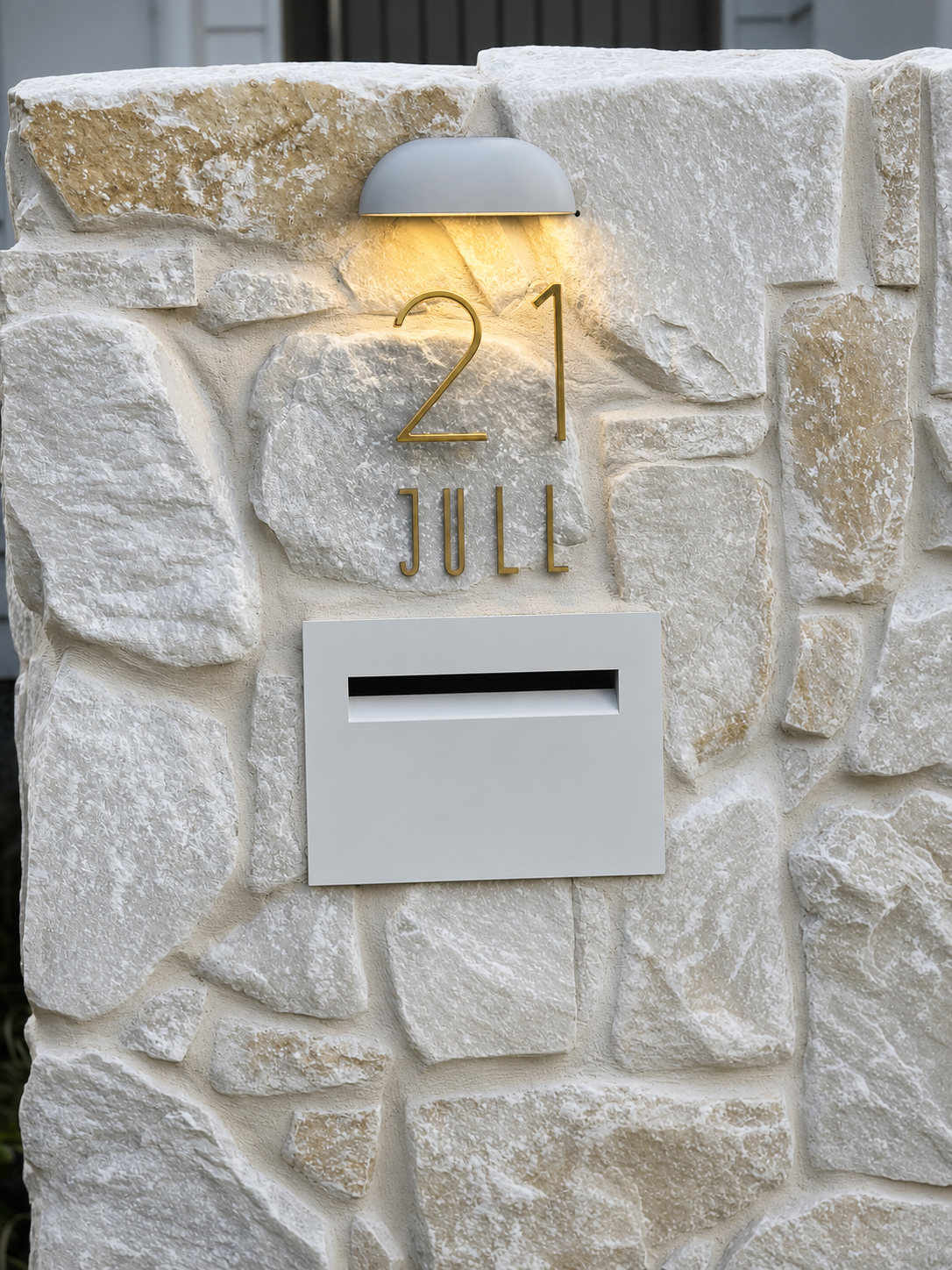Stone-clad entry pillar with brass '21 Jull' house numbers and modern mailbox