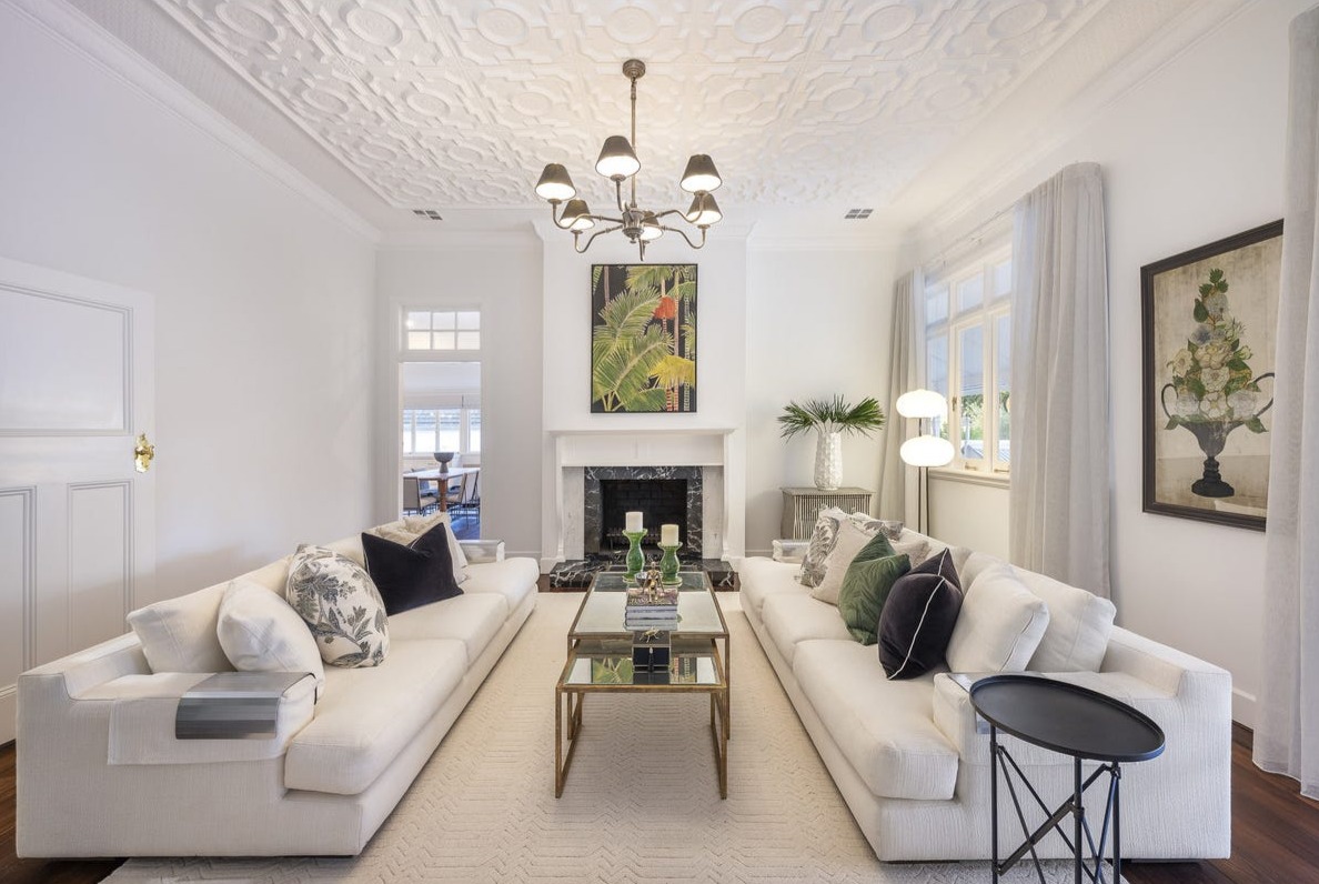 Formal living room with pressed metal ceiling, chandelier and marble fireplace