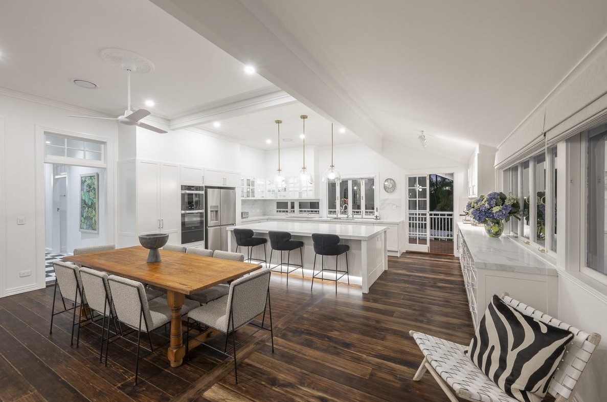 Open-plan kitchen and dining with raked ceiling and hardwood floors