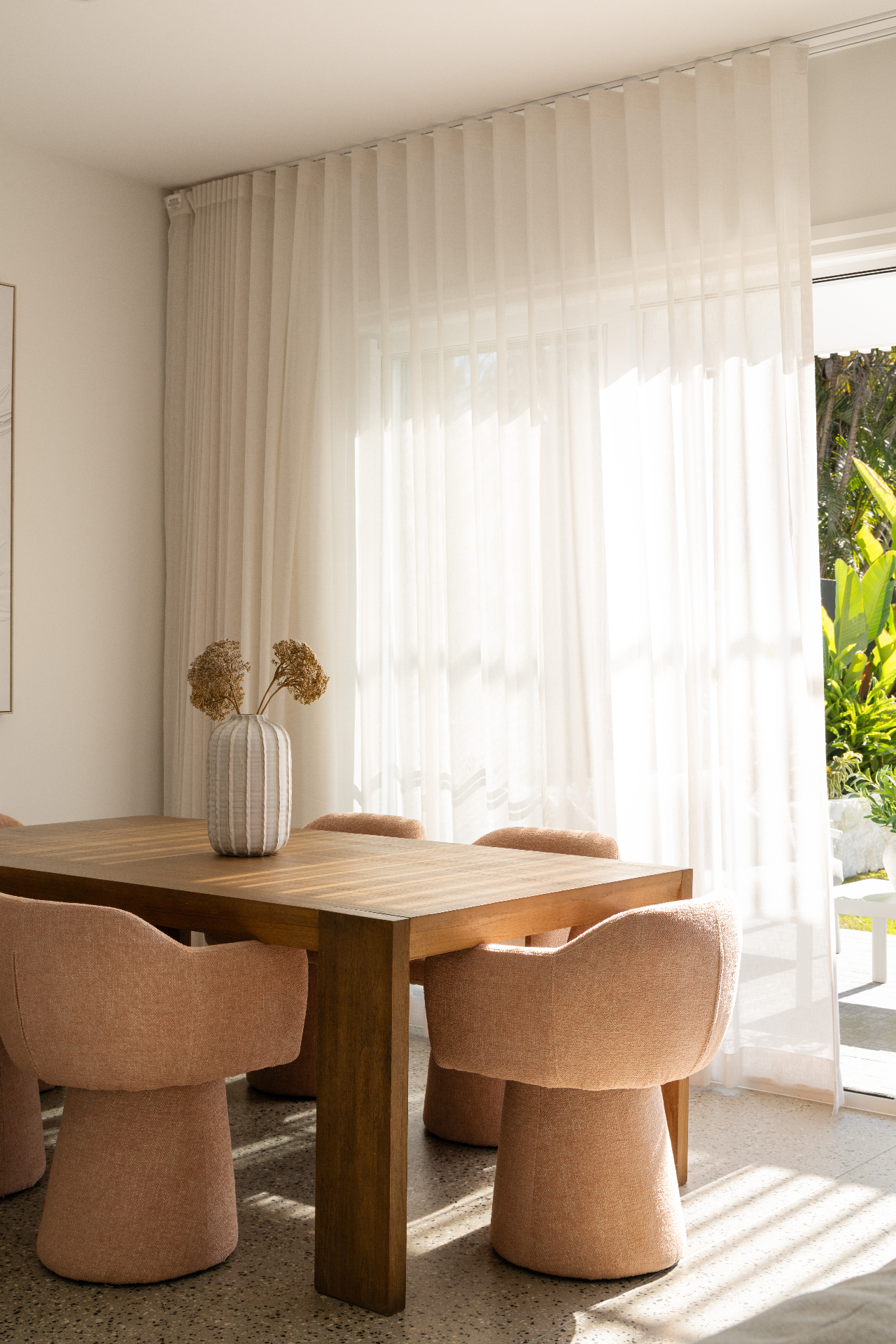 Sun-filled dining nook with sheer curtains and bouclé chairs, Geebung