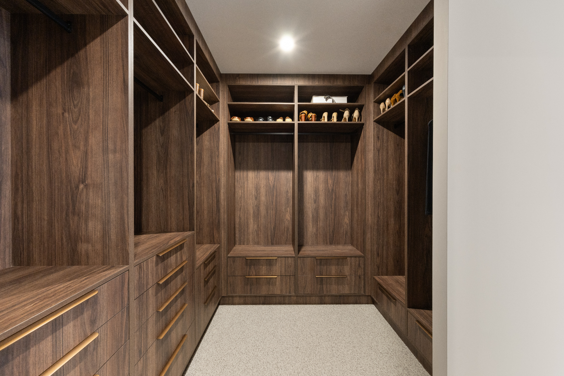 Walk-in robe with timber joinery, brass handles and integrated shelving, Geebung